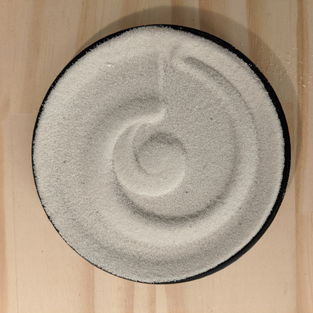 A circular plot drawn in sand using a wooden stylus.